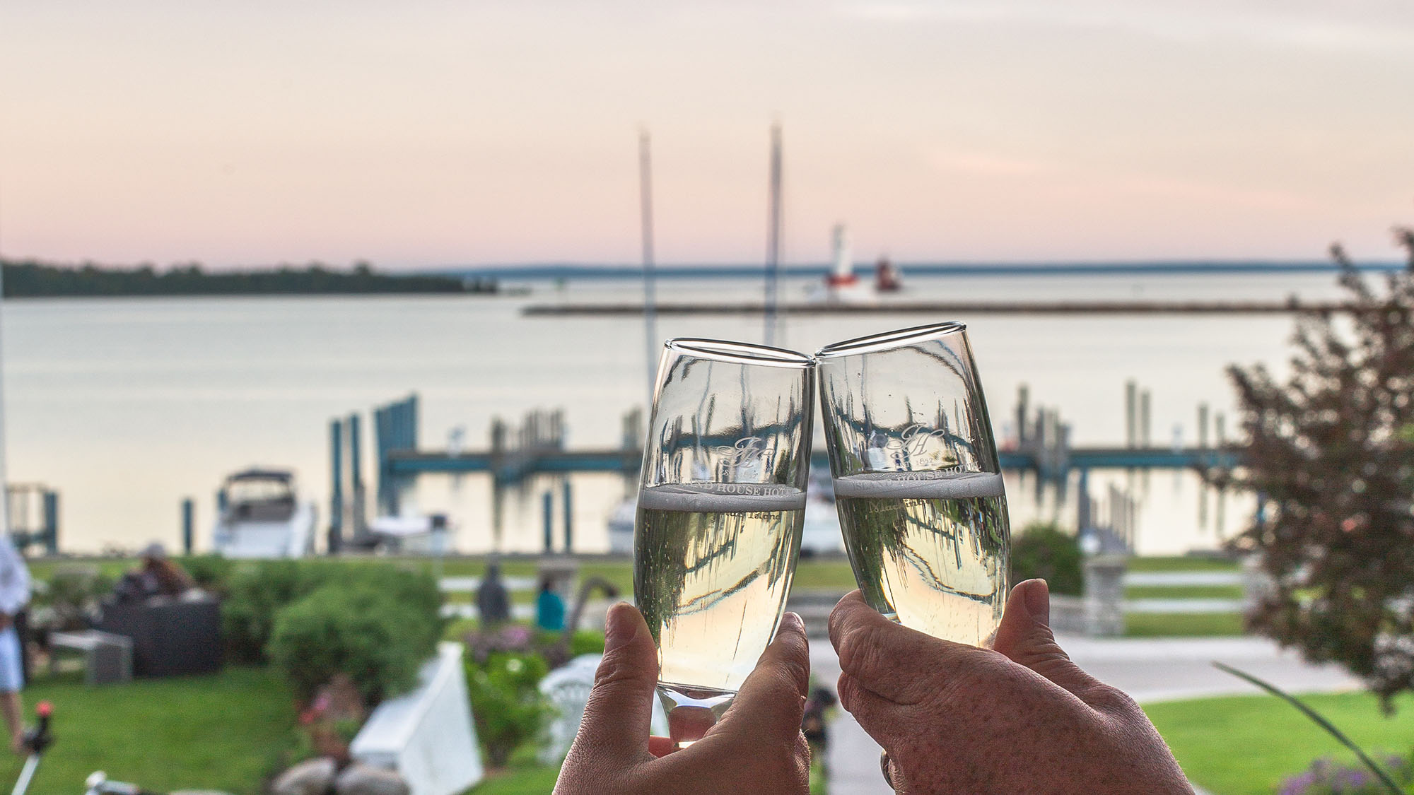 champagne glasses toasting with view of Harbor from Island House Hotel porch